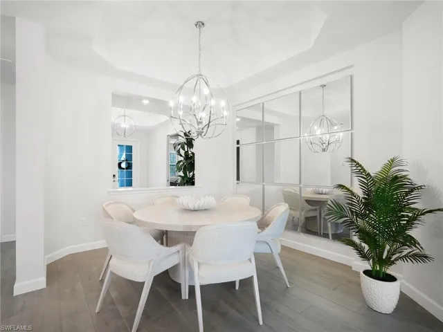 Dining area featuring a contemporary chandelier and tray ceiling