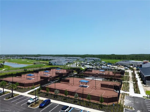 Multiple tennis courts with shaded seating areas