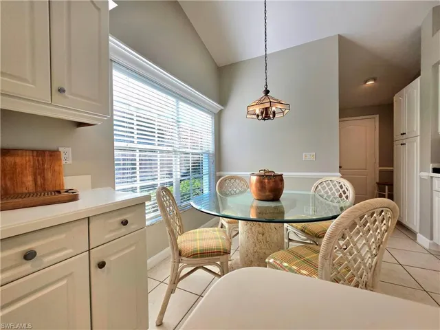 Dining area featuring light tile patterned floors and lofted ceiling