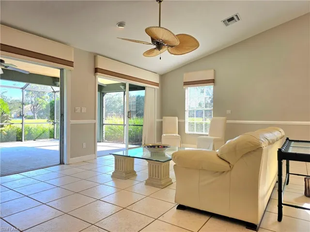 Living area featuring lofted ceiling, light tile patterned flooring, a fireplace, recessed lighting, and a ceiling fan