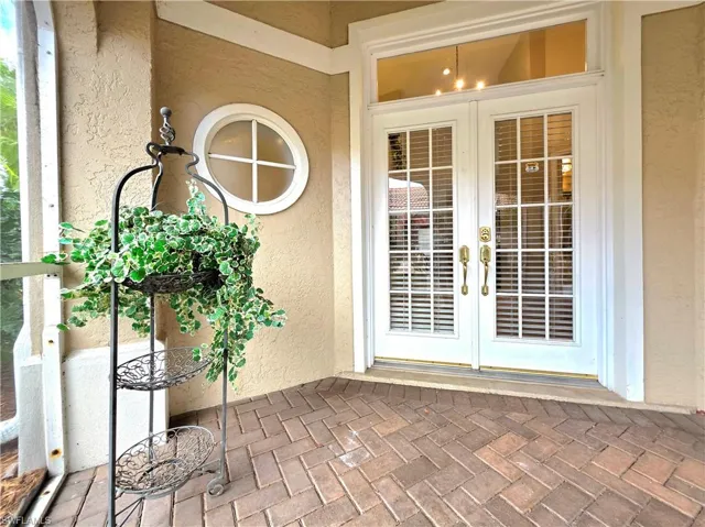 Doorway to property featuring french doors and stucco siding