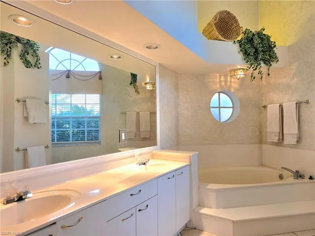 Empty room with lofted ceiling, light tile patterned floors, and ceiling fan