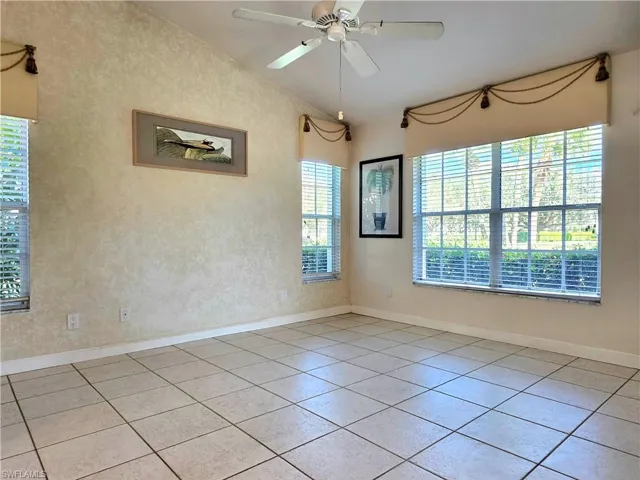 Living area with ceiling fan, vaulted ceiling, and light tile patterned floors