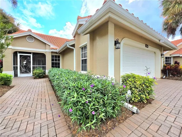 Mediterranean / spanish home with a tile roof, decorative driveway, stucco siding, a garage, and a front yard
