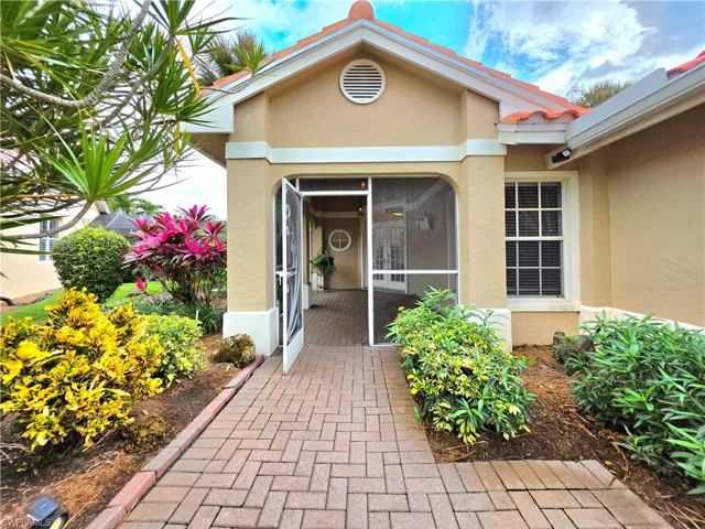 Entrance to property featuring stucco siding, a tile roof, and a sunroom