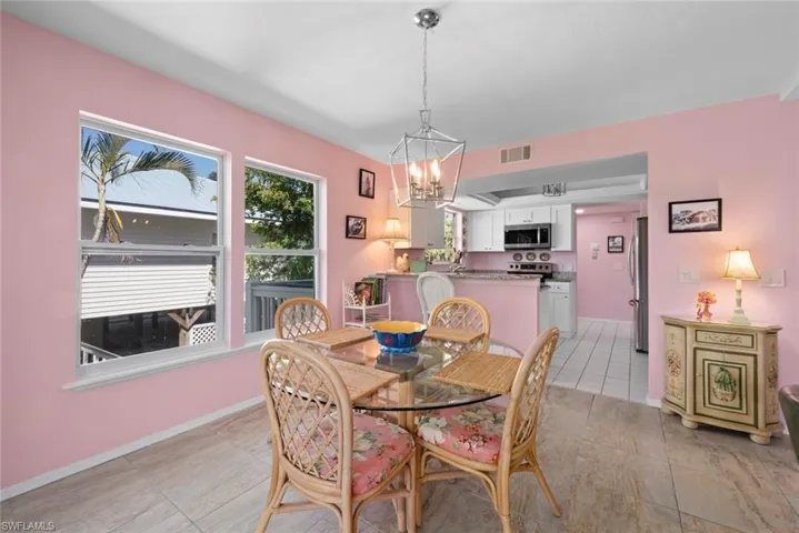 Dining area with a chandelier, visible vents, baseboards, and light tile patterned flooring