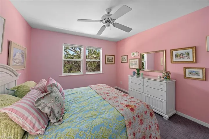 Carpeted bedroom with baseboards and a ceiling fan