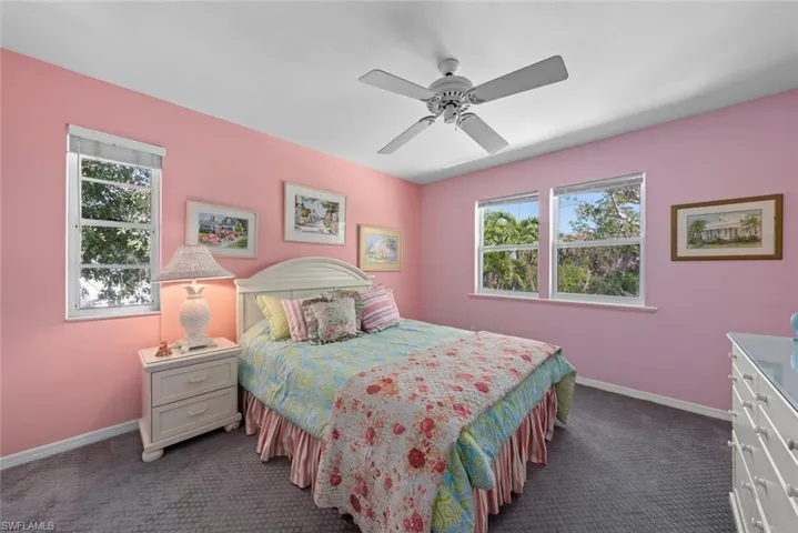 Bedroom featuring baseboards, multiple windows, and dark colored carpet