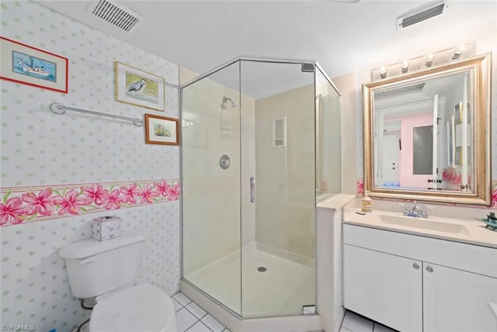 Bathroom featuring a shower stall, tile patterned floors, visible vents, and wallpapered walls