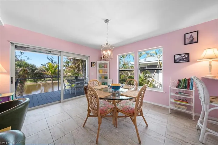 Dining area with a chandelier, light tile patterned floors, a water view, and baseboards