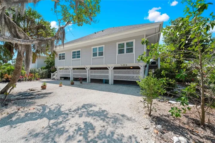 View of front of property with a carport, driveway, and stairway