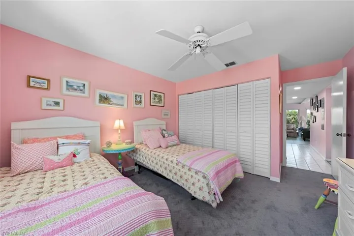 Carpeted bedroom featuring visible vents, ceiling fan, and a closet