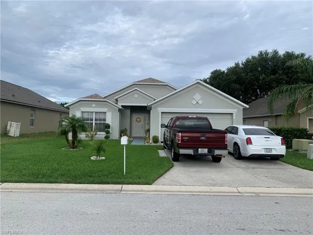 Single story home featuring a garage and a front yard