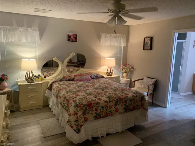 Bedroom featuring ceiling fan, a textured ceiling, and light hardwood / wood-style flooring
