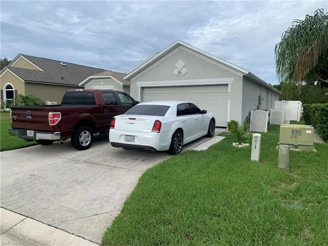 View of front of house with a garage and a front yard