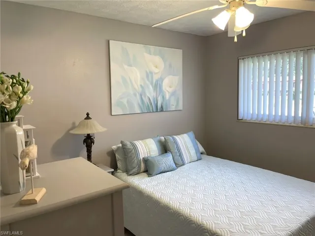 Bedroom with ceiling fan and a textured ceiling