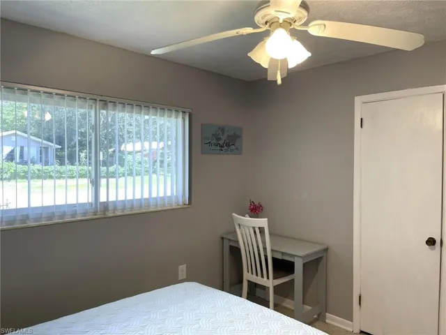 Bedroom with ceiling fan and multiple windows