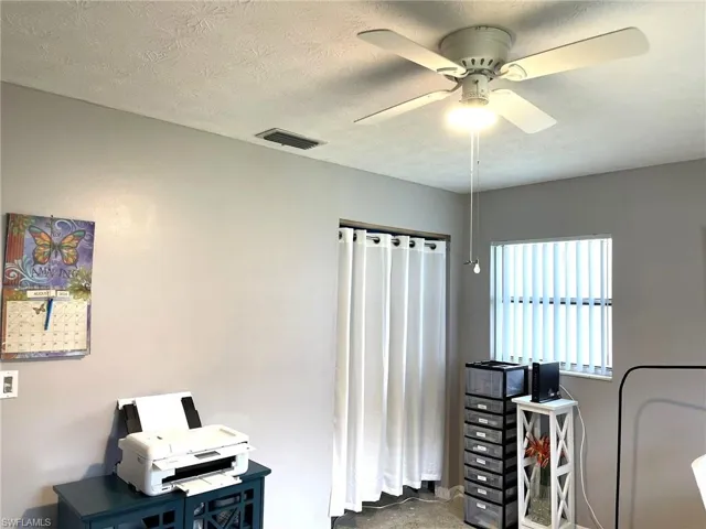 Office area with ceiling fan and a textured ceiling