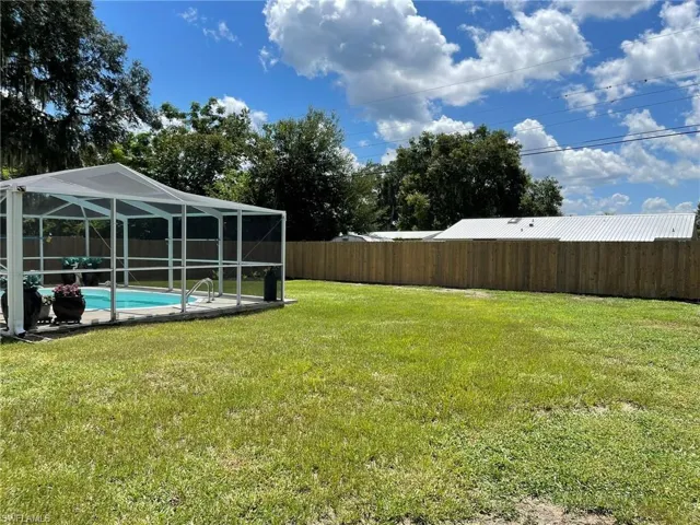 View of yard featuring a lanai and a fenced in pool