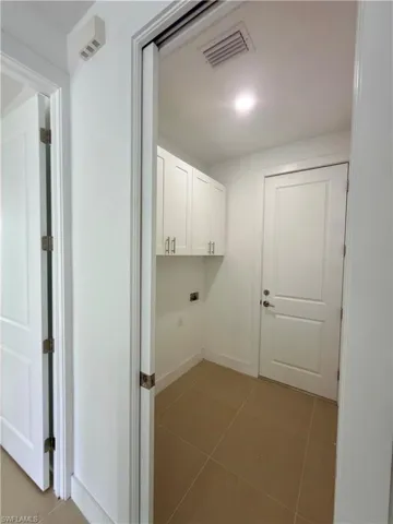 Washroom featuring dark tile patterned floors and baseboards