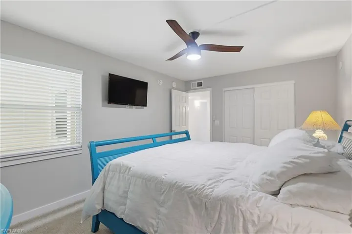 Bedroom with window, TV, and ceiling fan