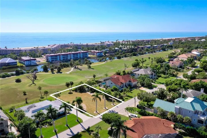 Aerial view of property and surrounding area featuring a large body of water, property parcel outlined, and a golf course