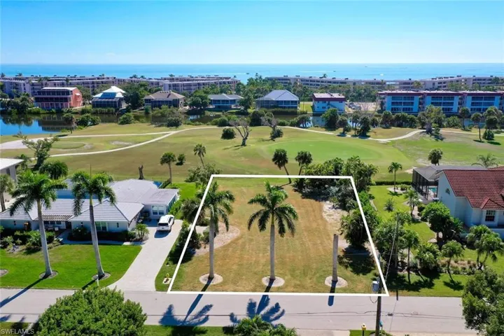 Aerial overview of property's location with a local golf course, a large body of water, and property parcel outlined