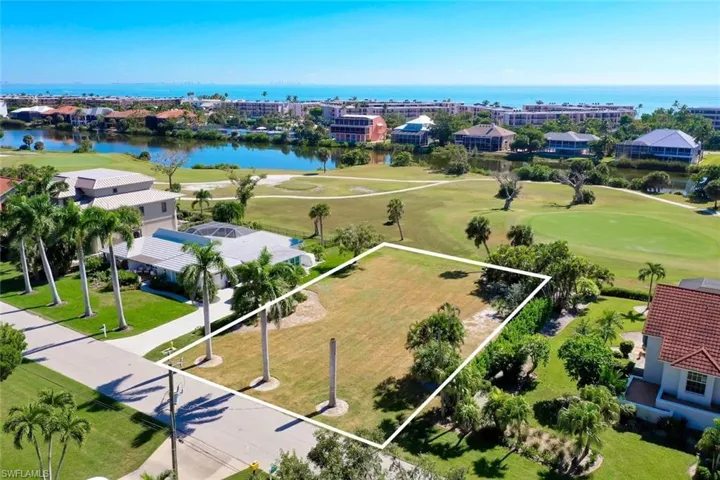 Aerial view of residential area with a large body of water, a local golf course, and property parcel outlined