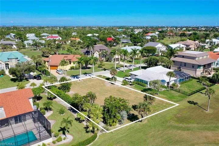 Aerial perspective of suburban area featuring property parcel outlined and a pool