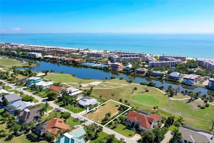 Aerial overview of property's location with a golf course, property boundaries highlighted, and a large body of water