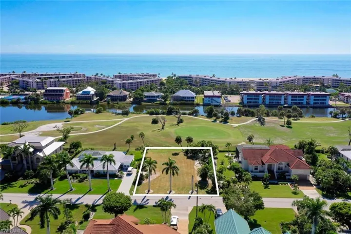 Aerial view of property's location featuring a large body of water, a local golf course, and property parcel outlined