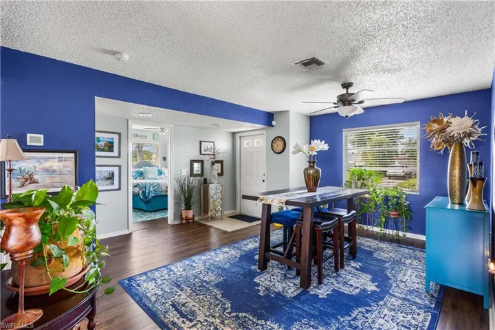 Dining room featuring dark wood-type flooring, a textured ceiling, and ceiling fan