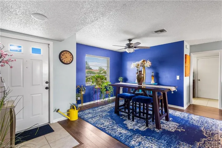 Dining space with a textured ceiling, light hardwood / wood-style flooring, and ceiling fan