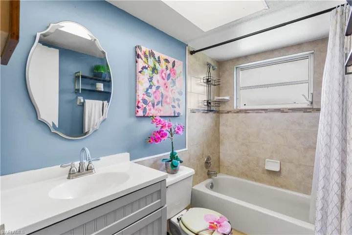 Full bathroom with toilet, shower / tub combo, and vanity