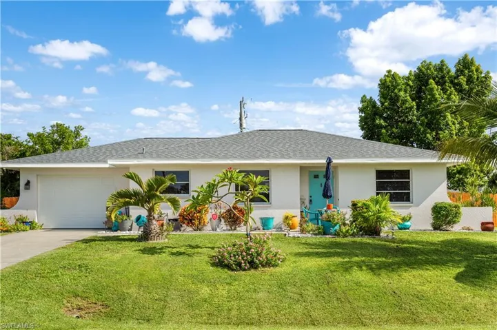 Ranch-style home featuring a garage and a front lawn