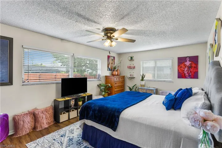 Bedroom featuring a textured ceiling, ceiling fan, and dark hardwood / wood-style flooring