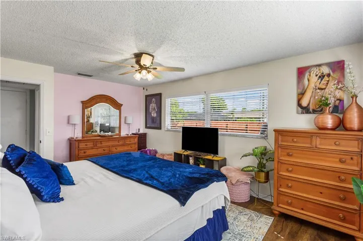 Bedroom featuring a textured ceiling, ceiling fan, and dark hardwood / wood-style floors