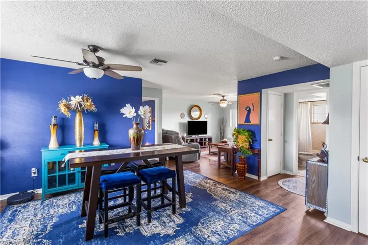 Dining space with a textured ceiling, ceiling fan, and dark hardwood / wood-style floors