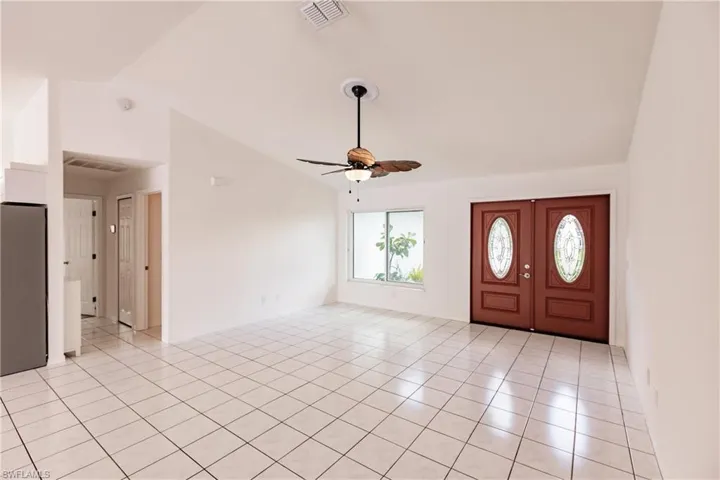 Tiled foyer entrance featuring vaulted ceiling and ceiling fan