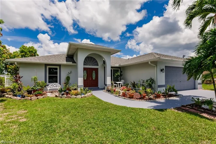 View of front of home with a garage and a front yard