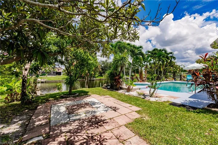 View of pool with a patio area, a yard, and a water view