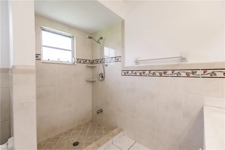 Bathroom featuring a tile shower and tile patterned floors