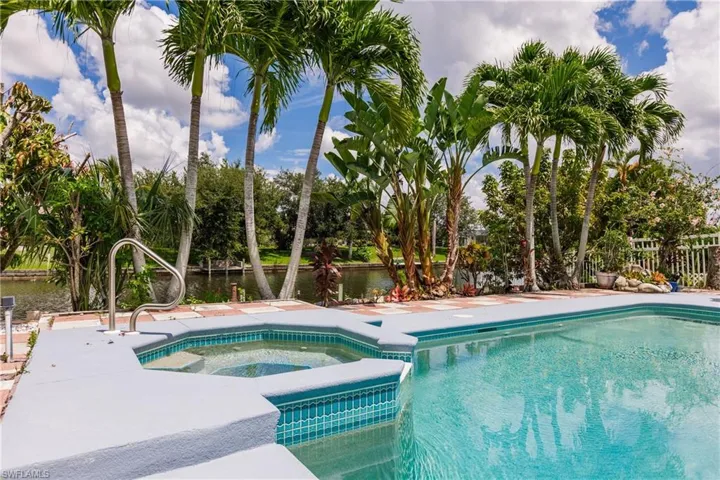 View of swimming pool featuring an in ground hot tub and a water view