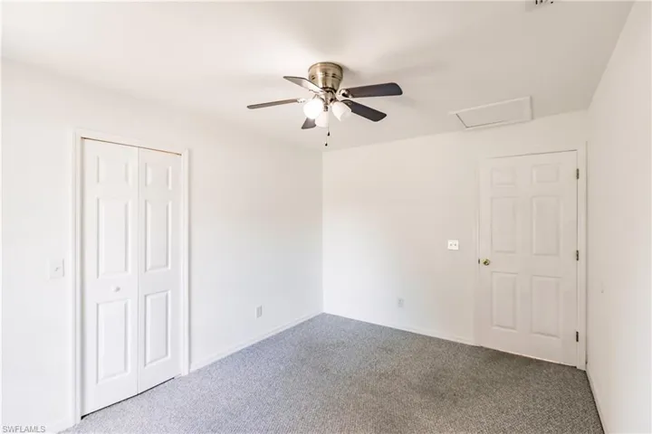 Carpeted spare room with ceiling fan