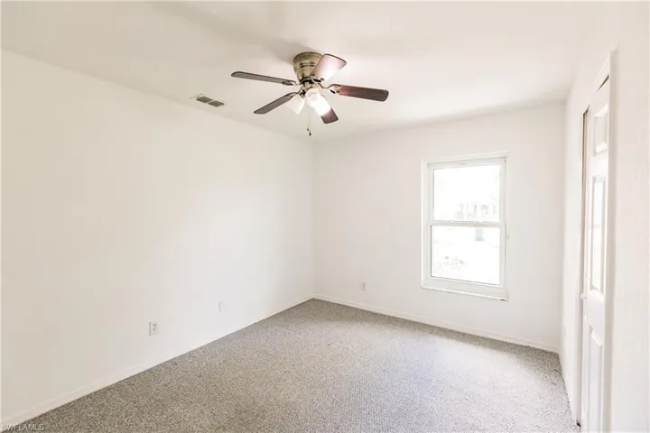Carpeted spare room with ceiling fan