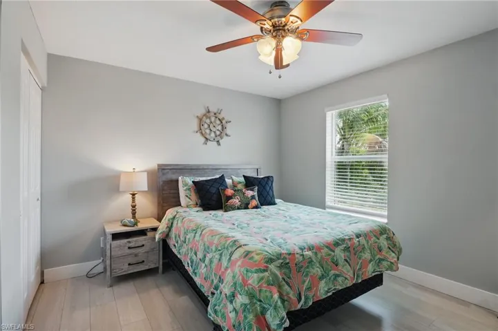 Bedroom featuring baseboards, light wood finished floors, a closet, and a ceiling fan