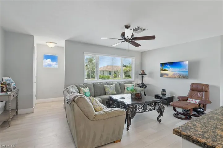 Living area featuring a ceiling fan, baseboards, light wood-style flooring, and visible vents