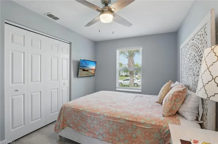 Bedroom with ceiling fan, a closet, visible vents, and wood finished floors