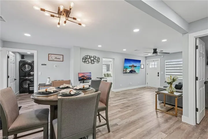 Dining room with estacked washer and dryer, light wood finished floors, and recessed lighting