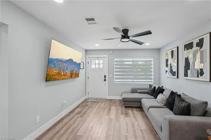 Living area featuring light wood-style floors, ceiling fan, and recessed lighting